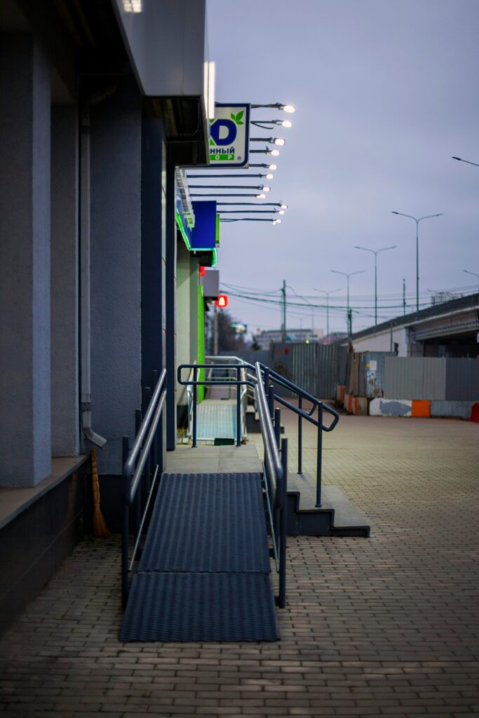 Photo of a non descript store or shop front with an accessible ramp and stairs leading to the entrance
